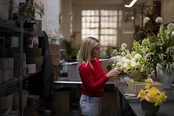 The Renata Ortega Florator, who lost her house and studio in The Eaton Fire, works on a floral arrangement in her temporary studio in Los Angeles, Friday, March 28, 2025 (AP Photo/Jae C. Hong)