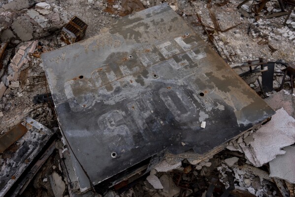 A sign for the small red chicken cafe is on the rubble after the business was destroyed by the Eaton fire from Altadena, California, on Friday, March 28, 2025. (AP Photo/Jae C. Hong)